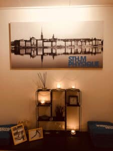 Tavla med en bild av Stockholm vid vattnet och Sthlm Physique logotyp i högra nedre hörnet